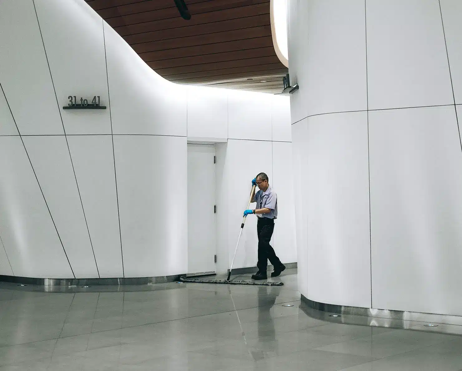 An Able Facility Solutions team member maintaining a bright, modern commercial lobby